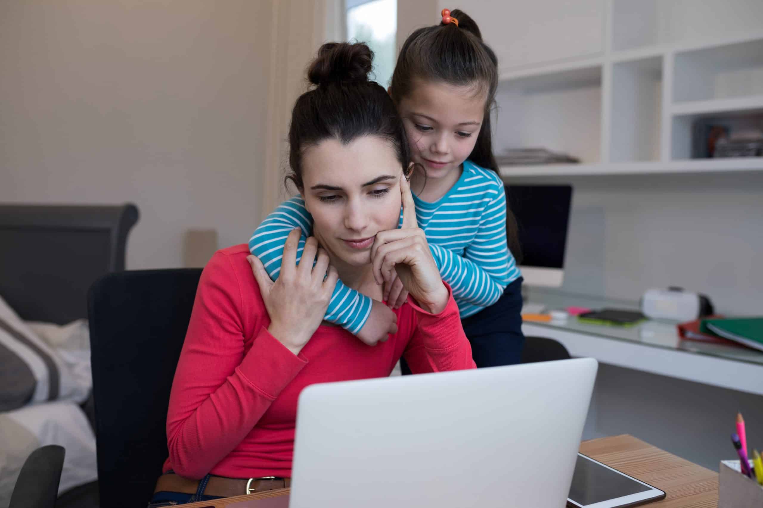 Mother and daughter using laptop at desk Understanding Scientific Research About Autism