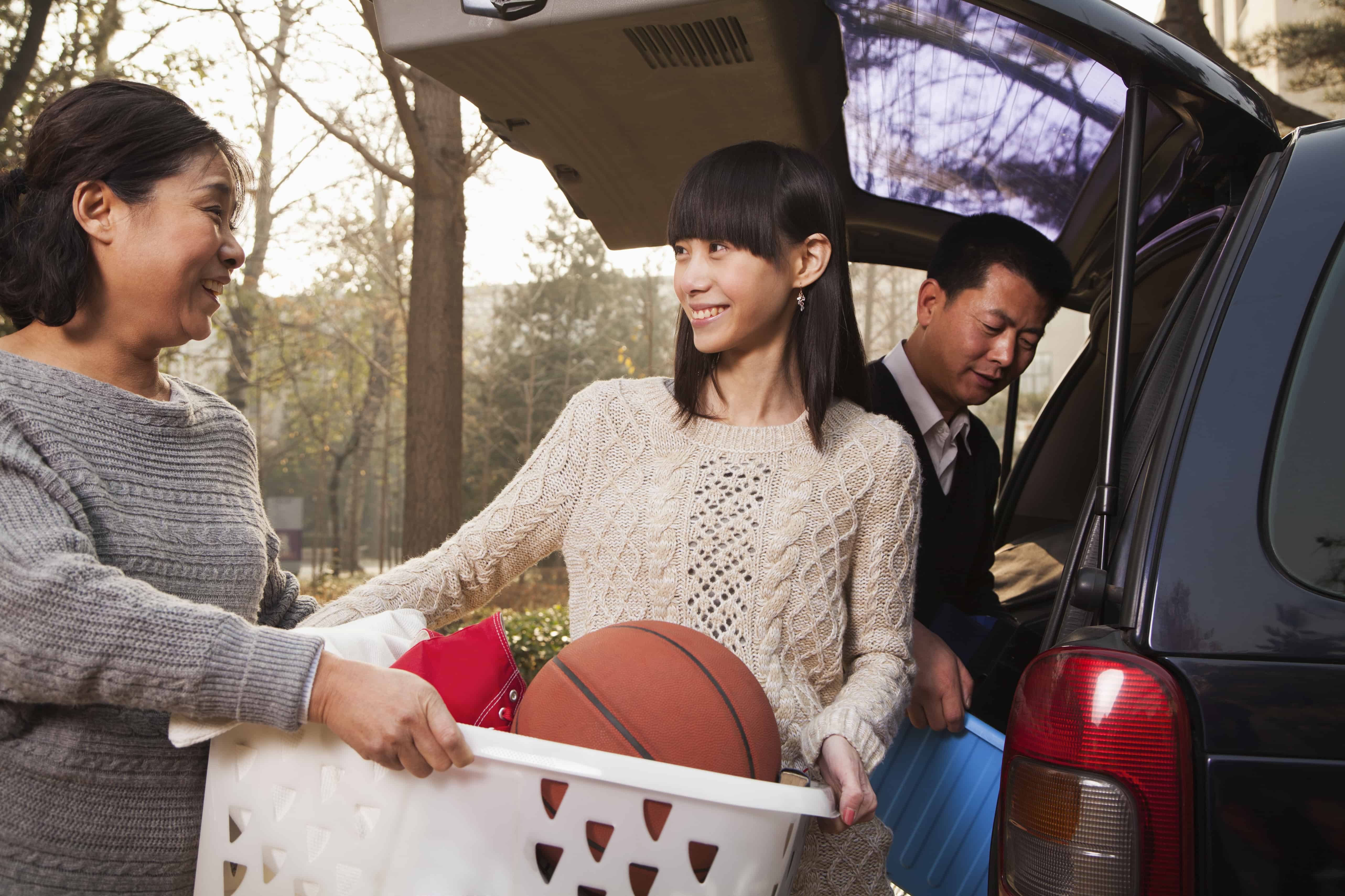 Mother helping daughter unpack car for college, Beijing college transition autism